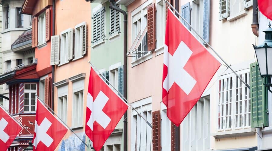 Zurich layover guide photo of the Swiss flag on buildings in Old Town Zurich.