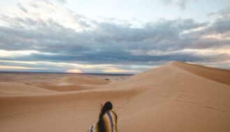 Best places for solo female travel photo of a woman alone in a desert.