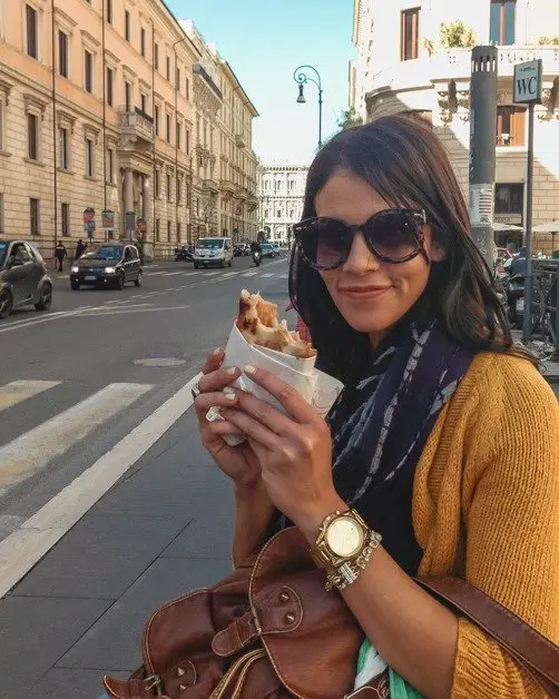 Me posing with a delicious pizza in my hand in Rome an awesome solo female travel destinations