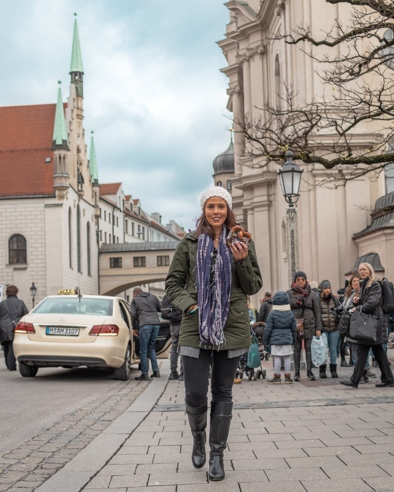 Picture of me holding a pretzel in Old Town Hall in Munich an awesome city for solo female travel