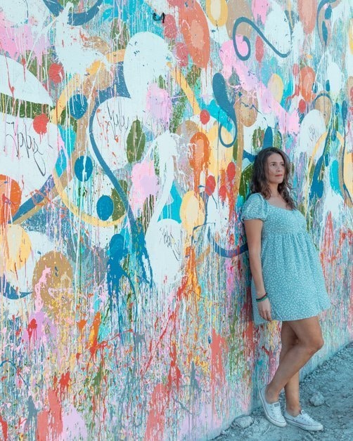 Standing in front of a colorful mural in Wynwood