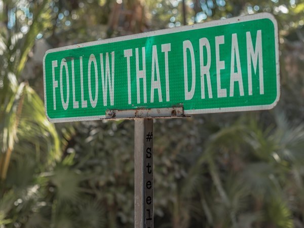 Street sign in Tulum that says follow that dream