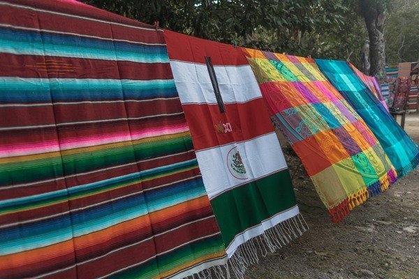 Color blankets hanging of a clothes line and swaying in the wind.