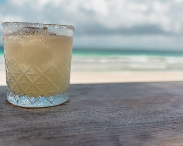 Margarita on a table eat a beach club with the ocean in the background