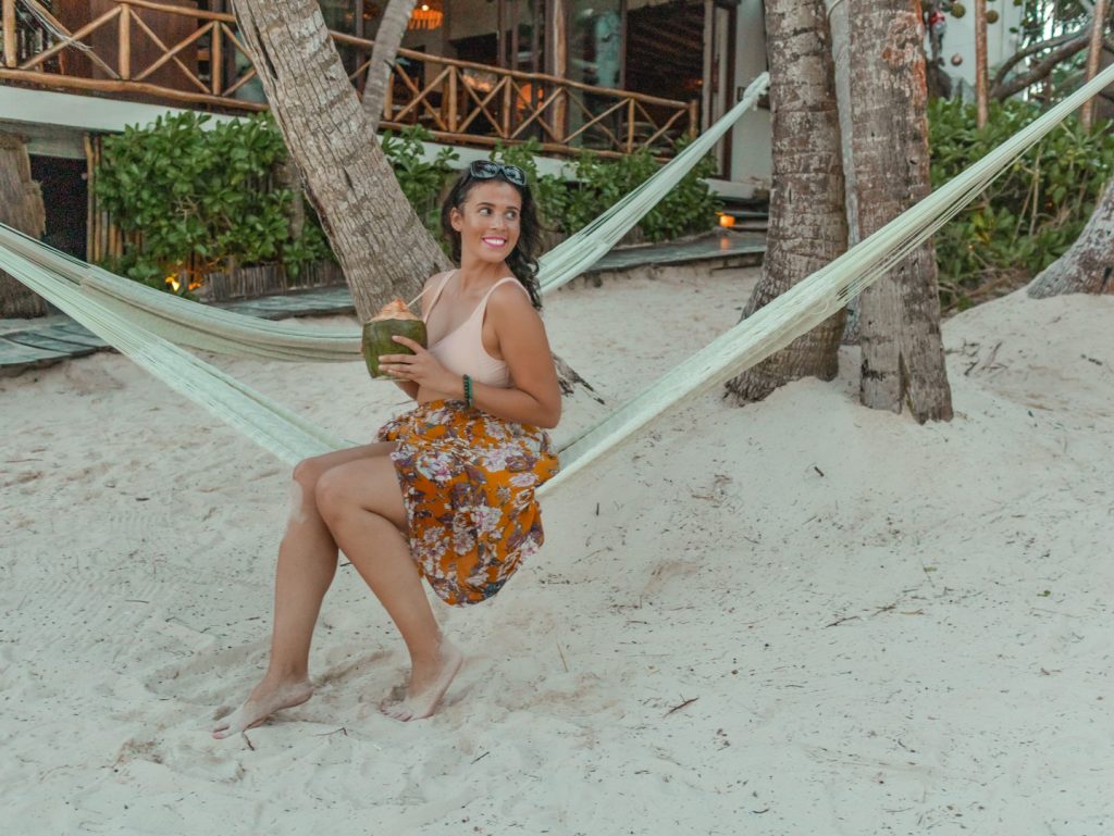 Me posing on a hammock with a coconut one of the things to do in Tulum. 