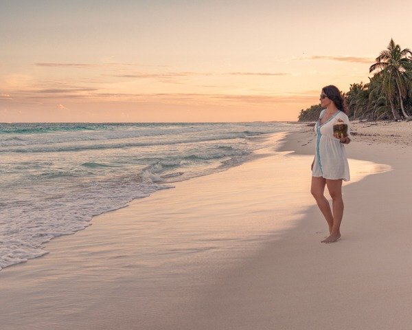 me staring at the ocean with a coconut during sunset in Tulum.