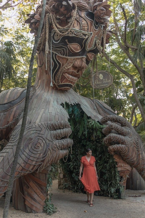 Me standing under the large wooden sculpture VEN A LA LUZ AT AHAU TULUM BEACH