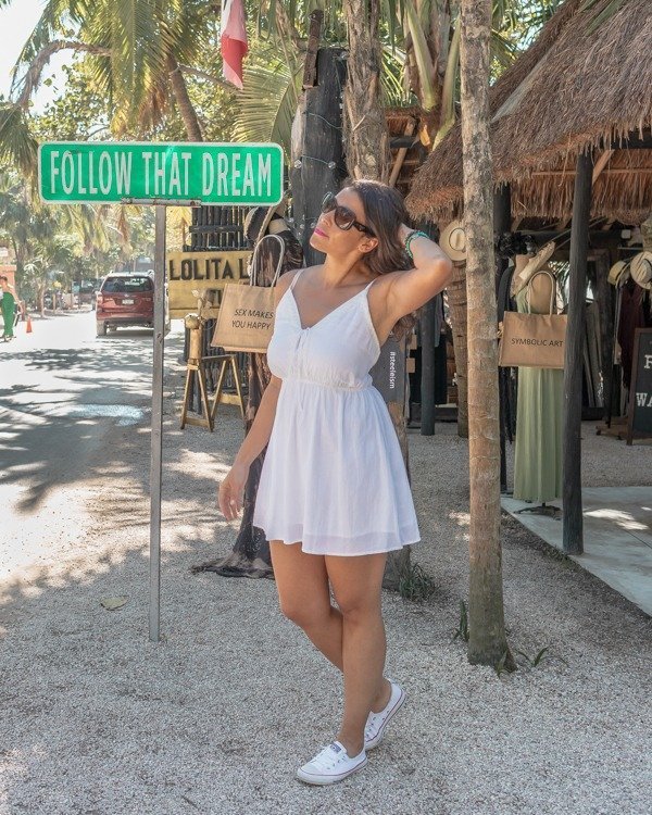 posing at the follow that dream sign one of the popular Tulum Instagram spots.