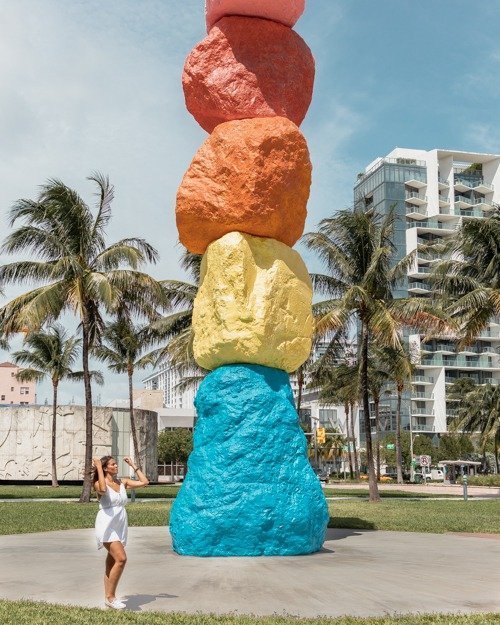 posing in front of the colorful rock art display on a sunny day