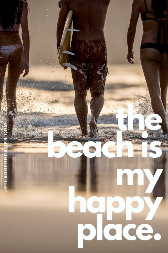 3 friends walking into the ocean to surf during sunset and a quote that says "the beach is my happy place."