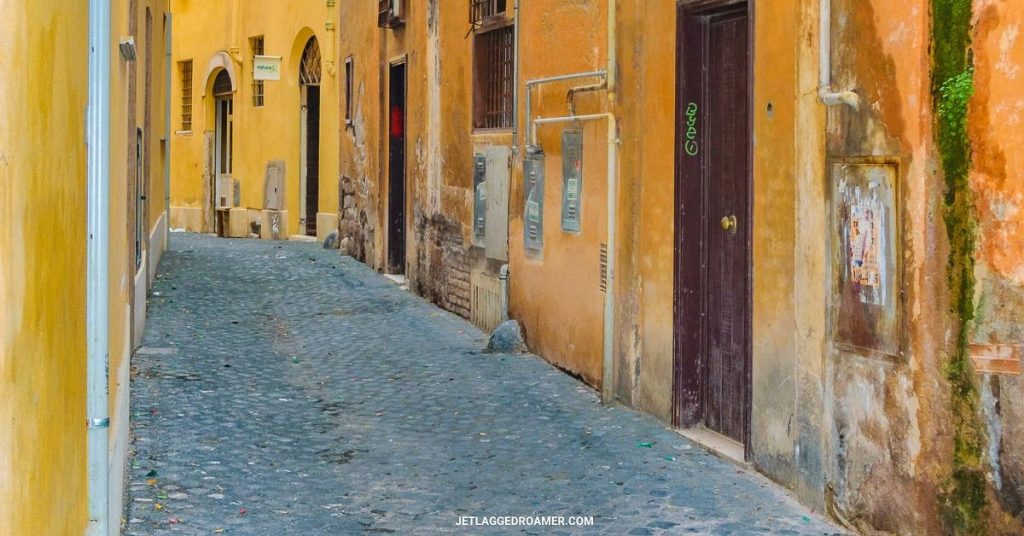 Empty alley somewhere in Europe with old buildings painted organe and yellow