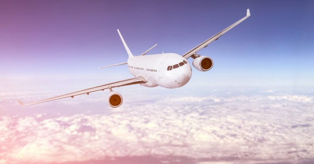 Airplane above the clouds on a sunny day. Photo for travel phrases to use on the plane. 