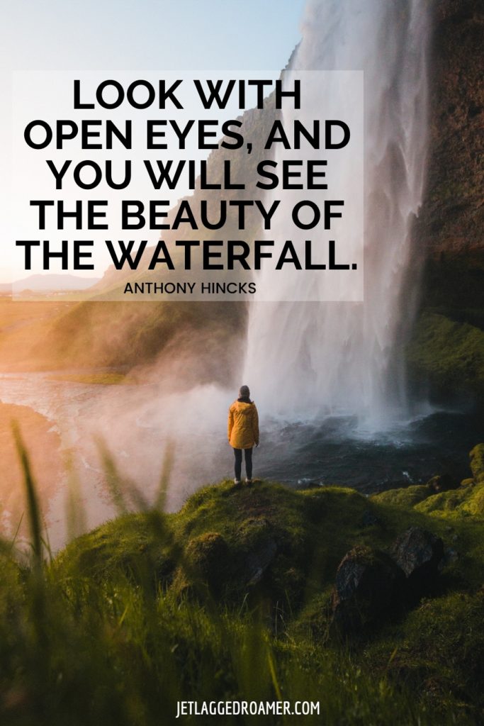 Woman standing on a grassy knoll looking at a waterfall fall and a quote about a waterfall that says “Look with open eyes, and you will see the beauty of the waterfall" by Anthony Hicks. 