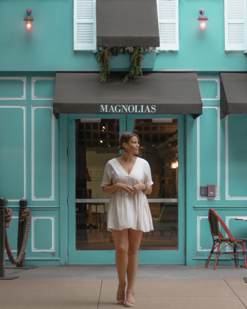 Me posing outside of Magnolias Sous Le Pont cafe, one of the cutest places to take pictures in Dallas.