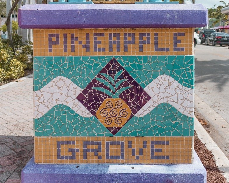 COLORFUL MOSAIC STAND THAT SAYS PINEAPPLE GROVE. 