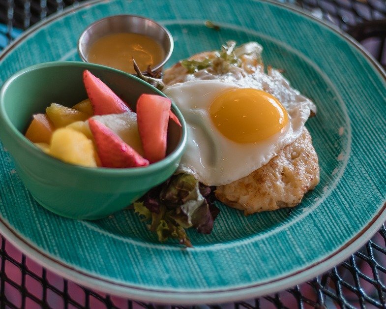 Crab cake eggs Benedict with a side of fresh fruit from Over The Bridge Cafe in Delray Beach. 