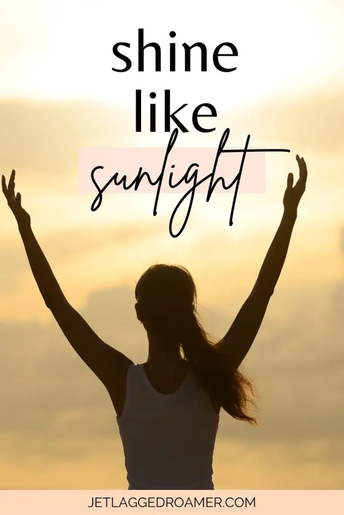 Sunlight caption for Instagram that says shine like sunlight. Silhouette of a woman in front of the beach with her arms up.