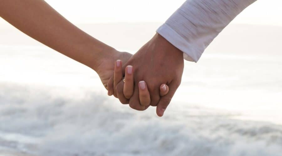 Photo for romantic things to do in Miami of a couple holding hands at the beach.