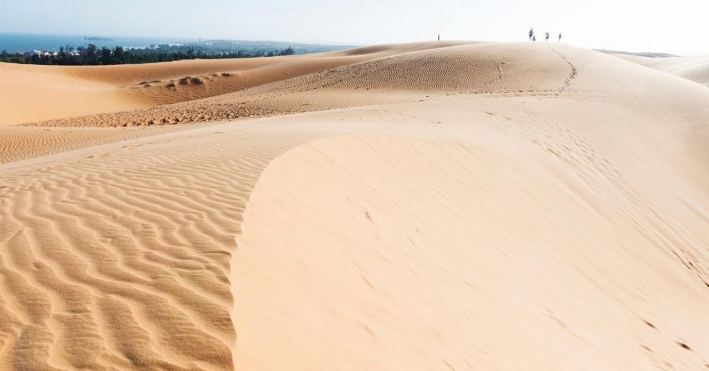 Desert Intsagram captions photo of a sand dune and sea. 