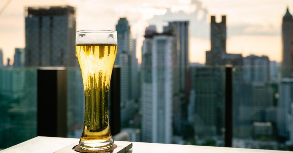 Balcony captions for Instagram photo of a pint of beer from a rooftop looking at the New York City skyline.