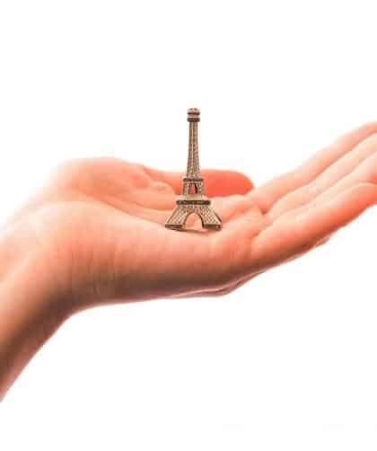 Souvenir Ideas photo of a hand holding a mini figurine of the Eiffel Tower.