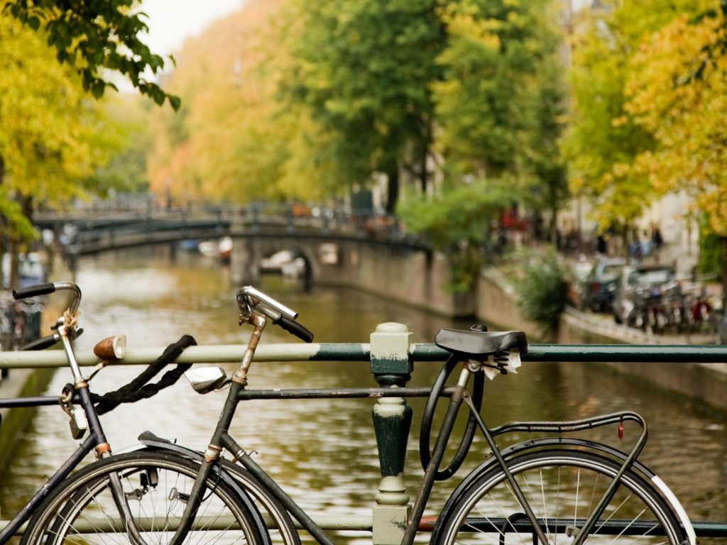 Amsterdam captions photo with a bicycle along the canal in Amsterdam, Netherlands. 