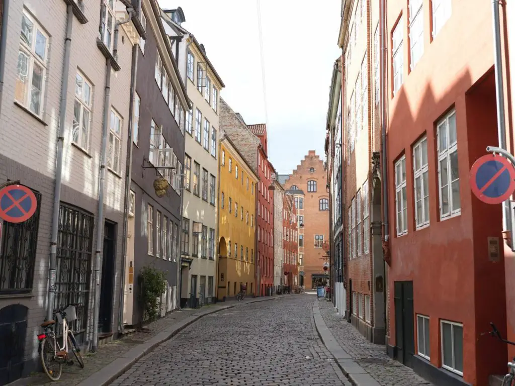 Copenhagen Instagram captions photo of a colorful cobblestone street in Copenhagen. 