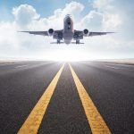 Flying captions photo of an airplane landing on the runway.