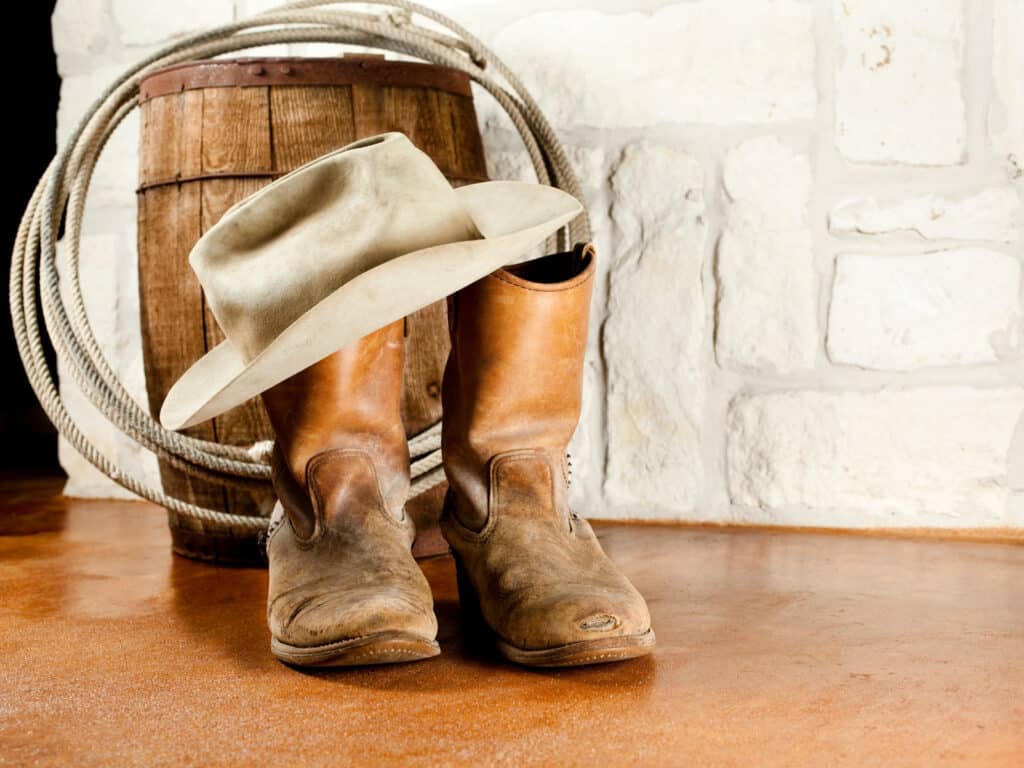 quotes about Texas photo of cowboy boot, hat, and a lasso.
