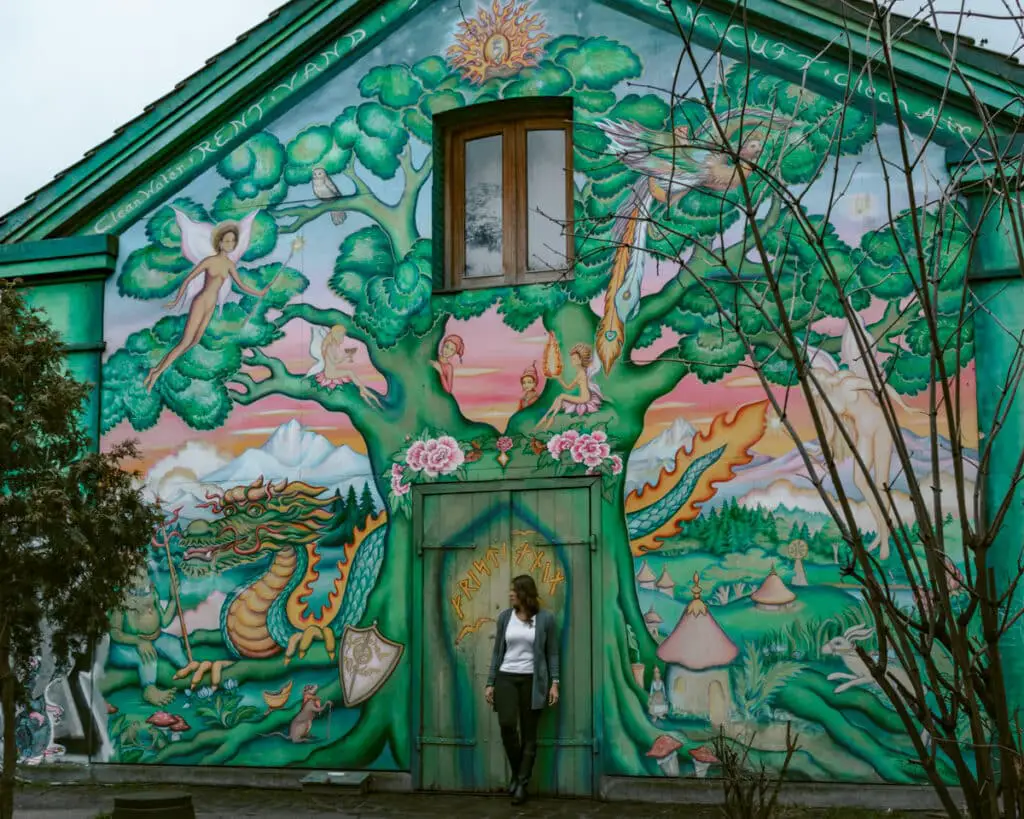 Me standing outside of a colorfully painted house in Christiania a Copenhagen Instagram spot. 