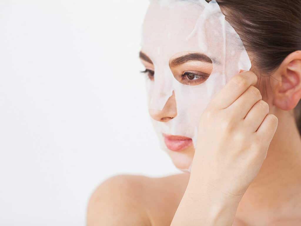 Woman with sheet mask take care of your skin while traveling photo. 