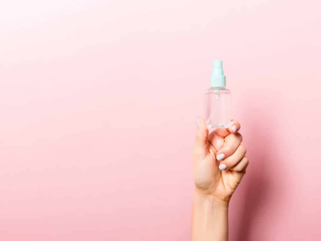 Take care of your skin while traveling photo of a woman holding facial essence.