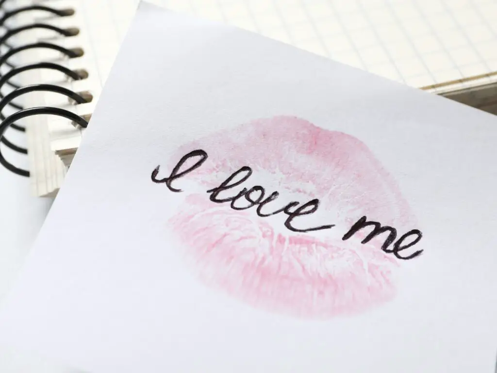 Love yourself quotes for Instagram photo of a notepad that says I love me and a lipstick imprint. 