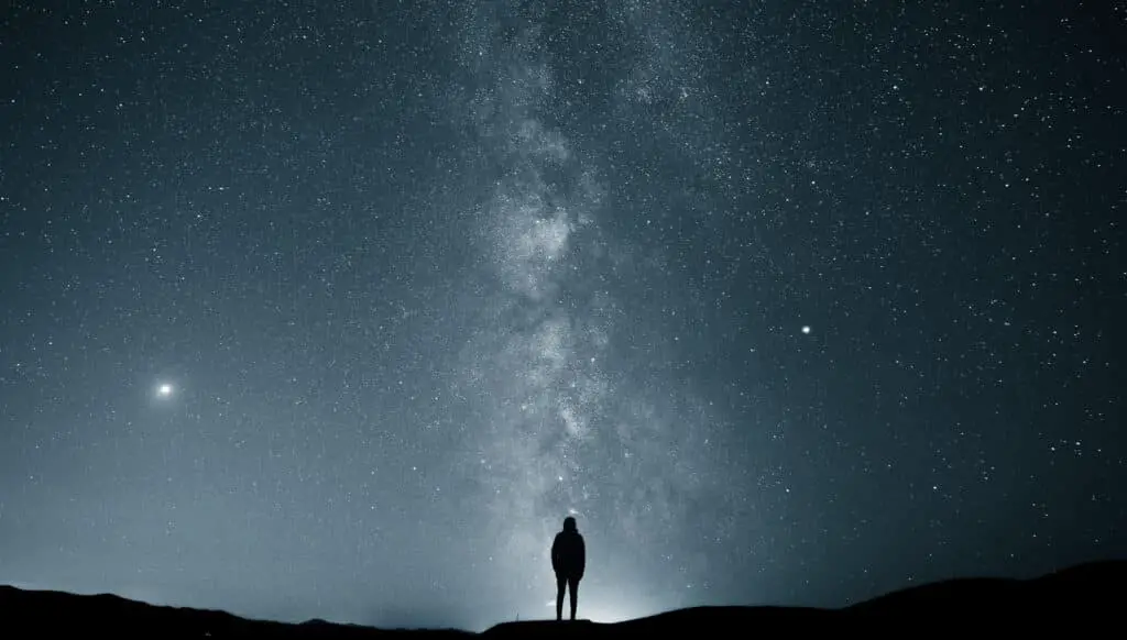Star captions photo of a man looking at the stars alone. 