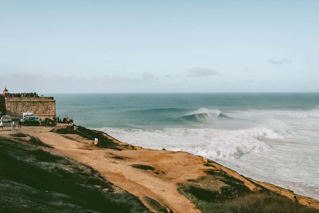 Waves crashing on the coast of Nazare. One of the beach day trips from Porto.
