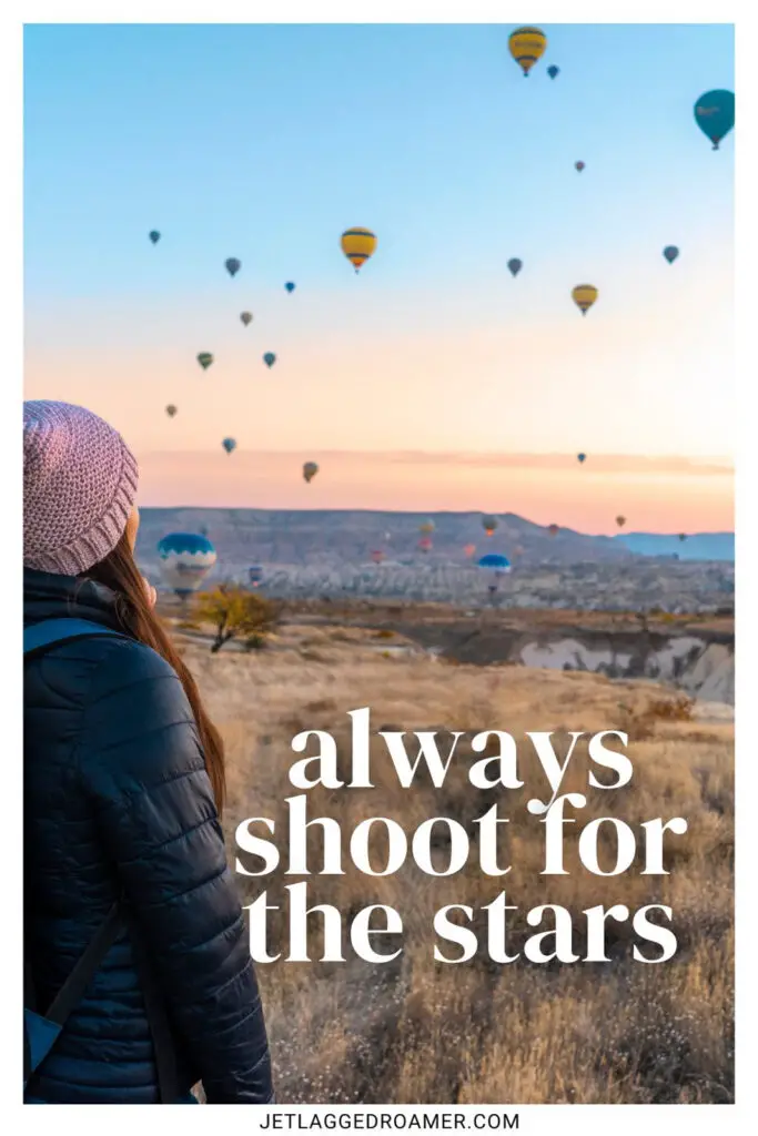 One of the bucket list captions that says always shoot for the starts. Woman looking at hot air balloons. 