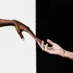 Photo for black and white captions for Instagram of two hands holding with a black and white background.