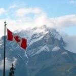 Canada Instagram captions photo of the Canadian flag in front of a snow-capped mountain