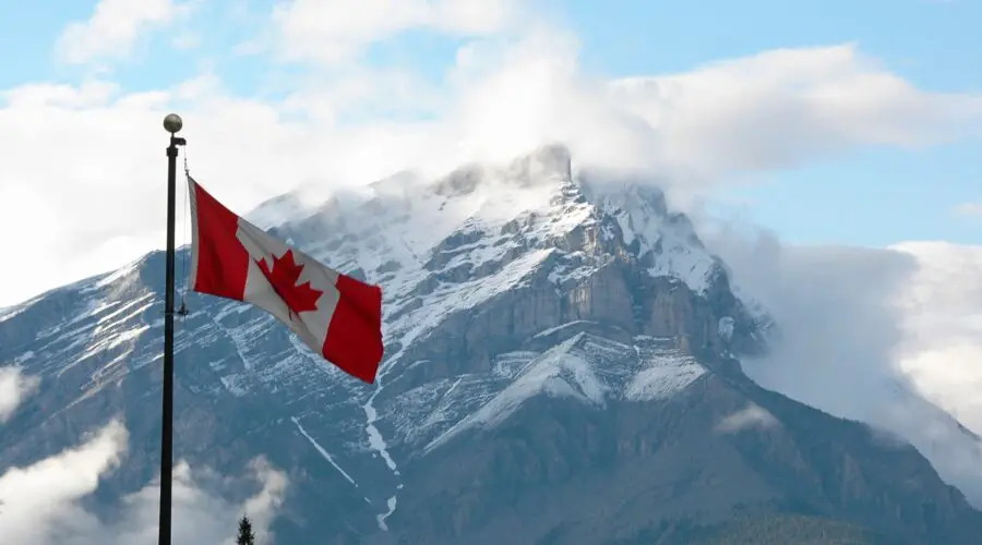 Canada Instagram captions photo of the Canadian flag in front of a snow-capped mountain